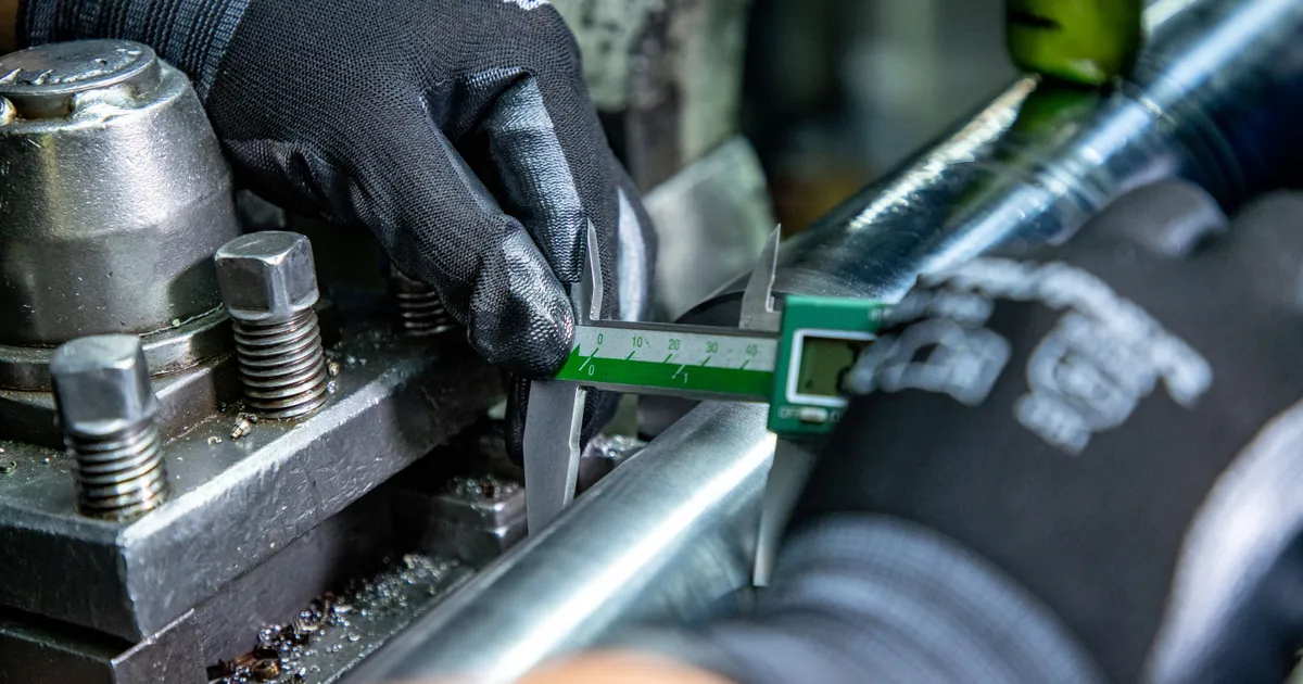 Vernier digital midiendo el diámetro de una flecha montada en el torno