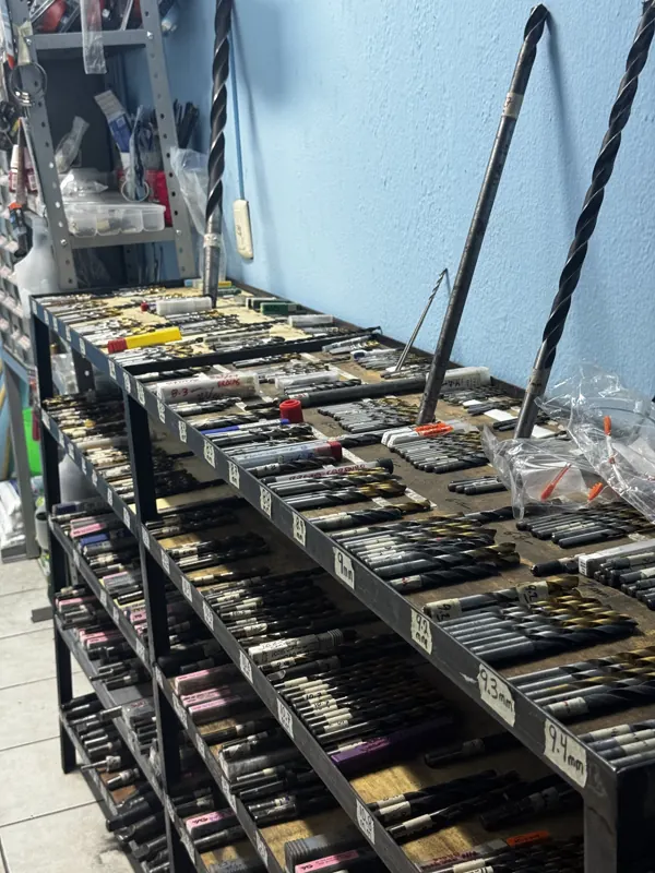 Estante de brocas ordenadas por medida en el taller de Maquinados López