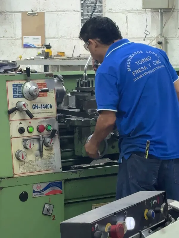 Tornero de Maquinados López trabajando una pieza en el torno convencional del taller